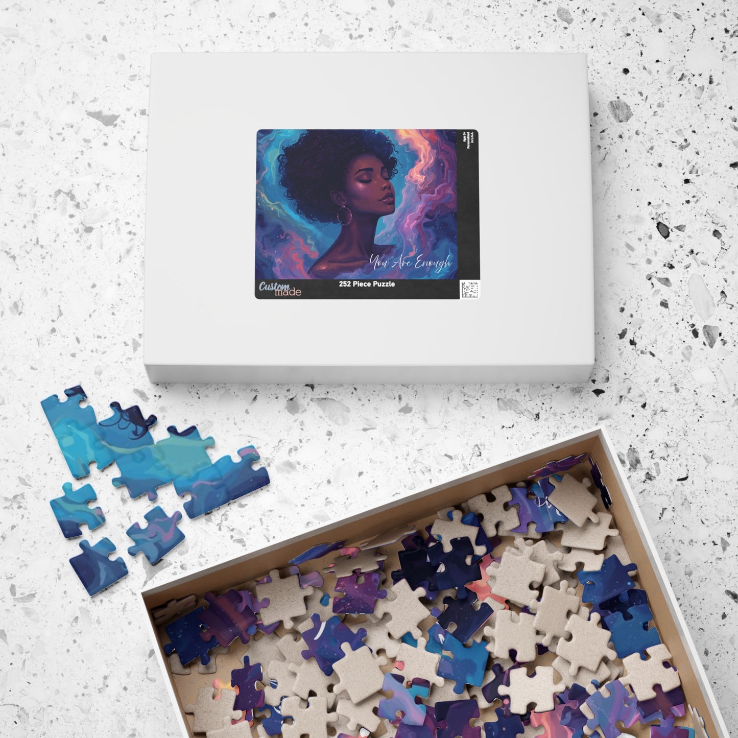 Jigsaw puzzle set with a box featuring an artistic design on a textured surface
