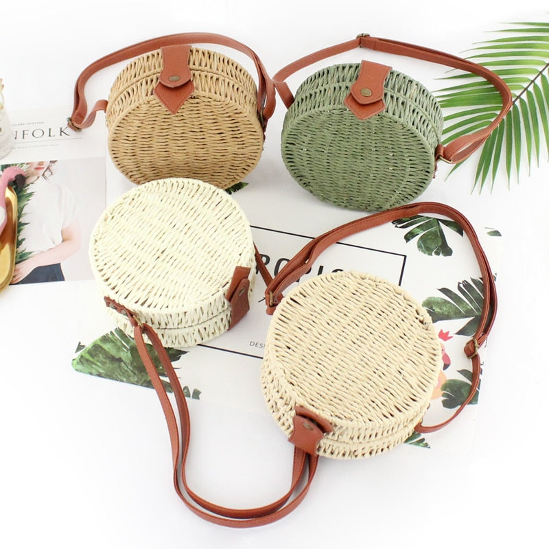Woven handbag with leather straps on a white background