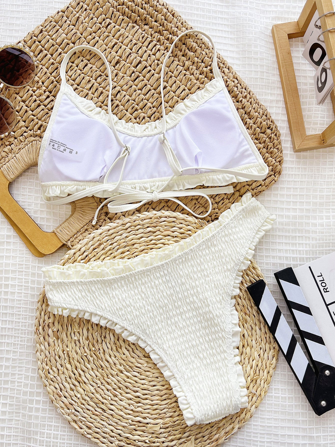 White scrunchy-patterned bikini with matching top and bottom, featuring spaghetti straps.