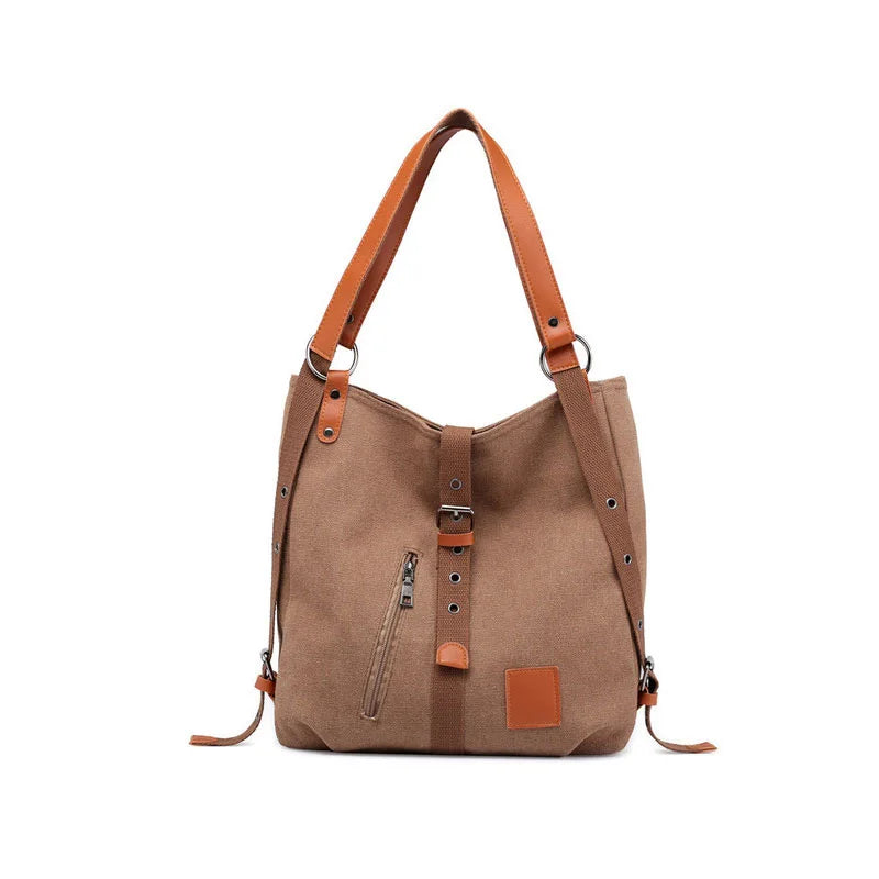 Women’s soft canvas backpack in coffee with zipper closure, top handle, and shoulder straps, featuring external pockets and a casual everyday design.