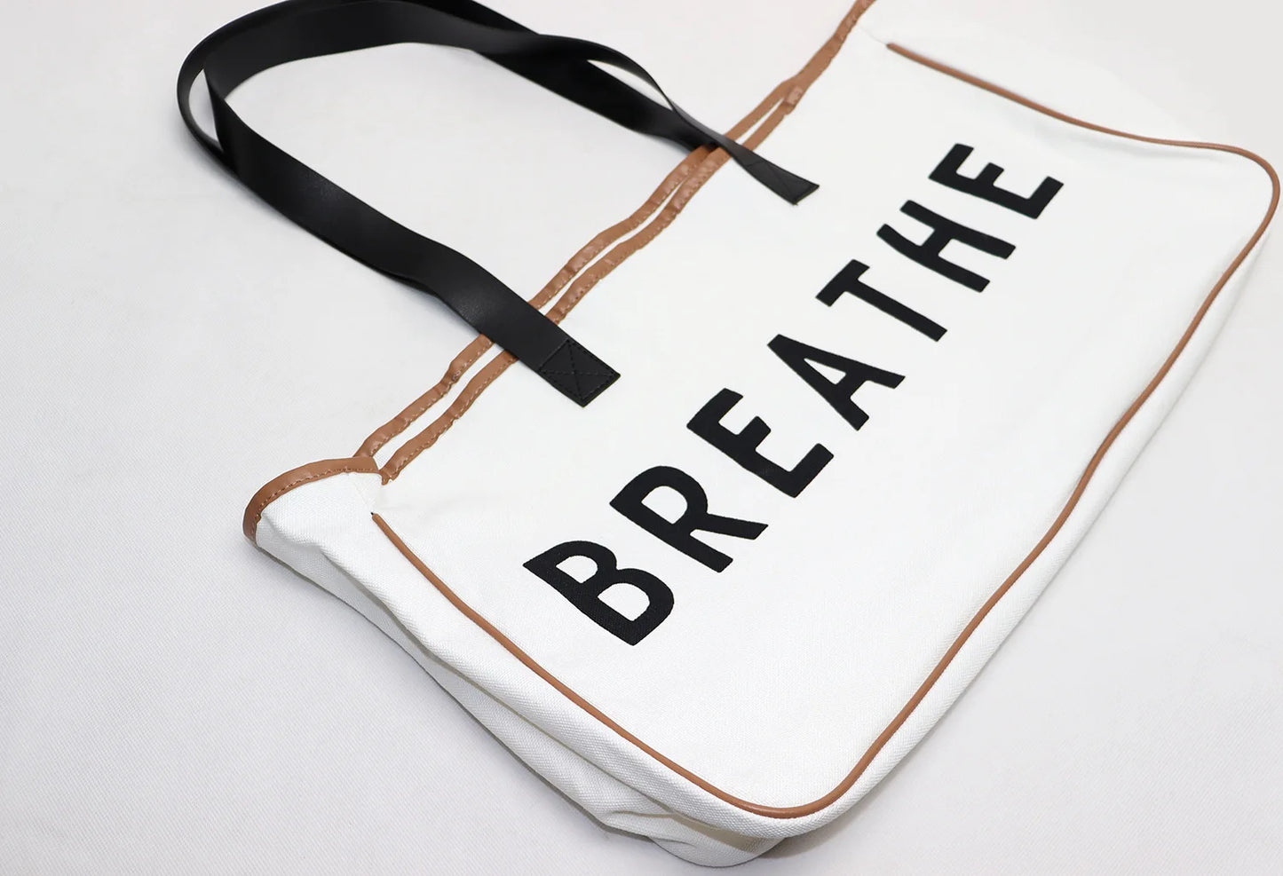 Tote bag with 'BREATHE' text on a light background