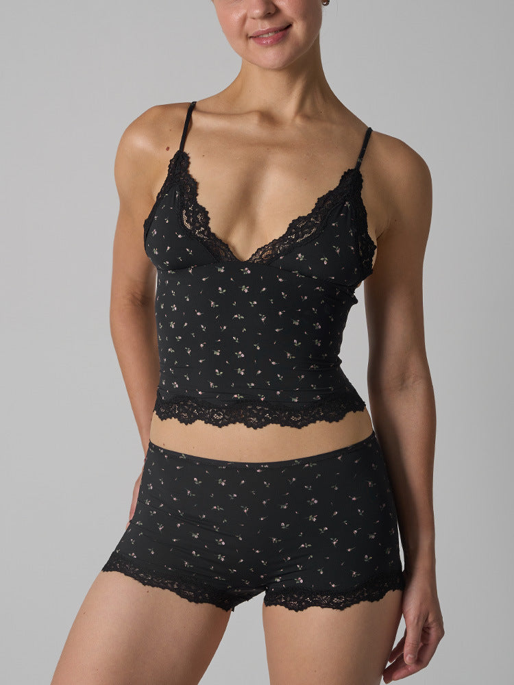 Black lace lingerie set worn by a model on a gray background