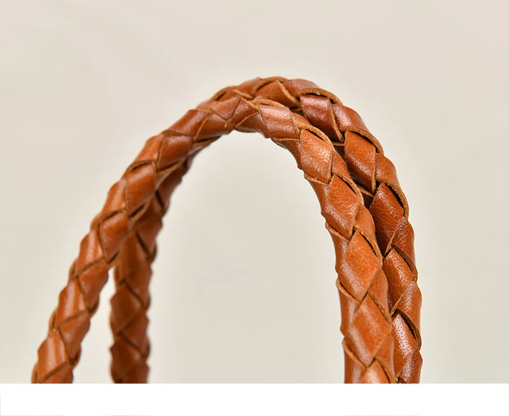 Close-up of a braided brown leather handle on a beige background
