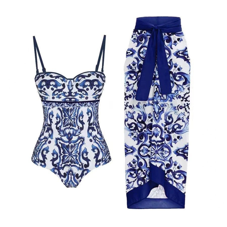 Retro‑style one‑piece swimsuit featuring a blue and white porcelain floral print, scoop neckline, moderate coverage back, and matching skirt high‑cut leg for a vintage silhouette.