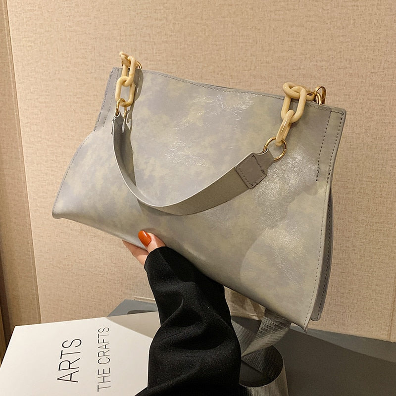 Large women's shoulder bag in soft faux leather, front view showing smooth finish and slim silhouette, black variant. Sold at PeachyBeanz.