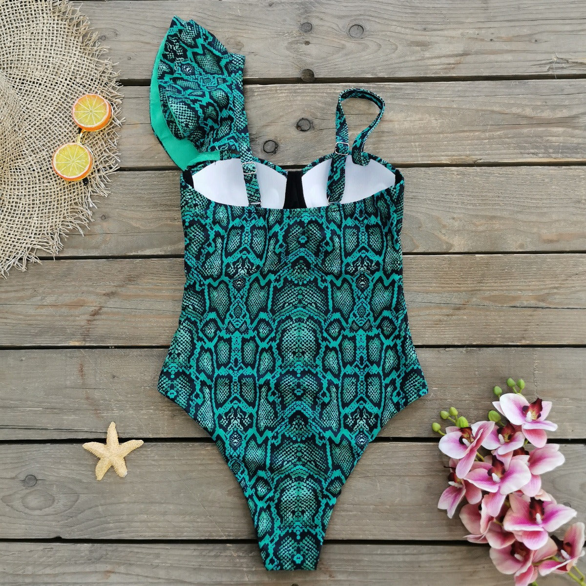 Teal and black patterned swimsuit on a wooden surface