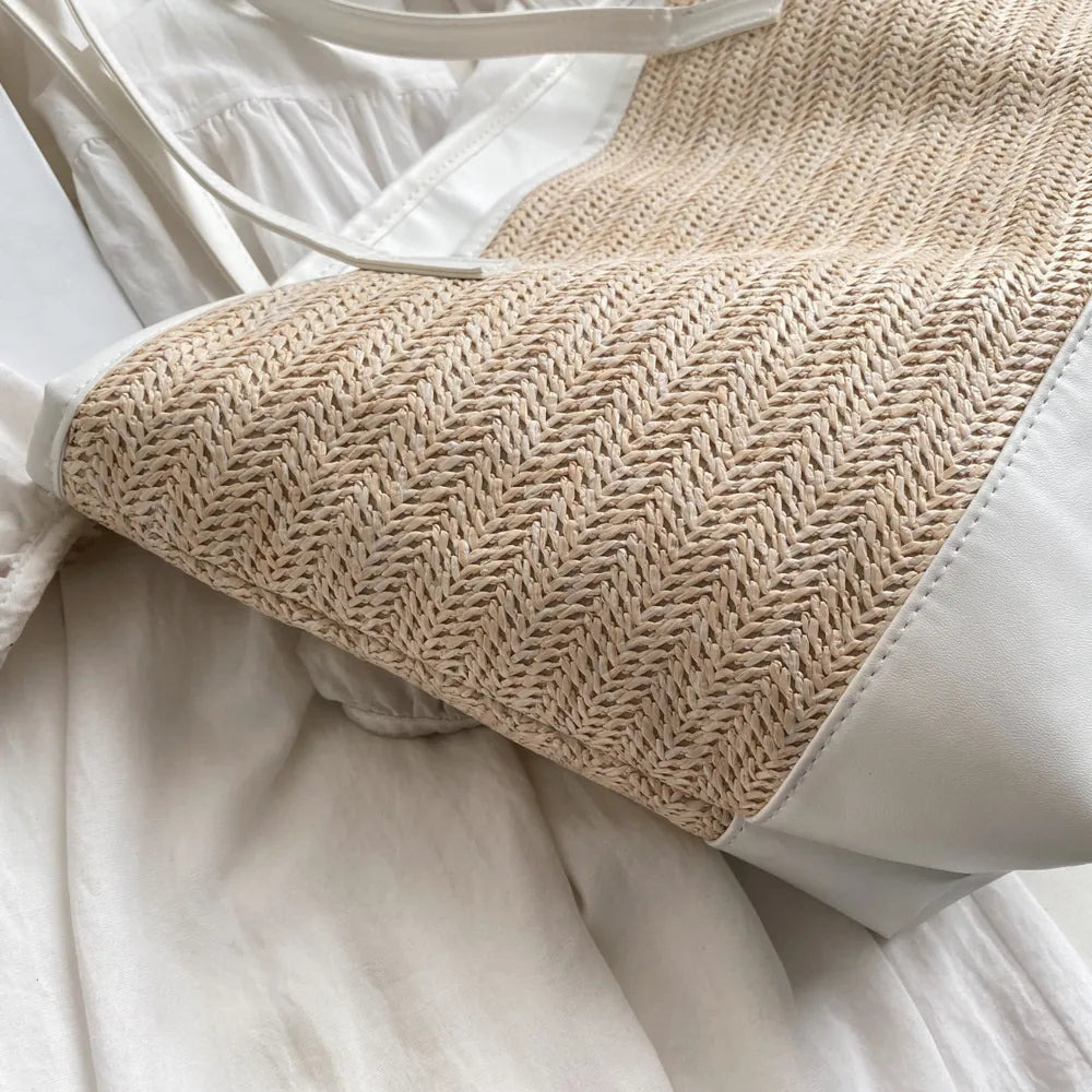 Large white straw bag laying down on white cloth.