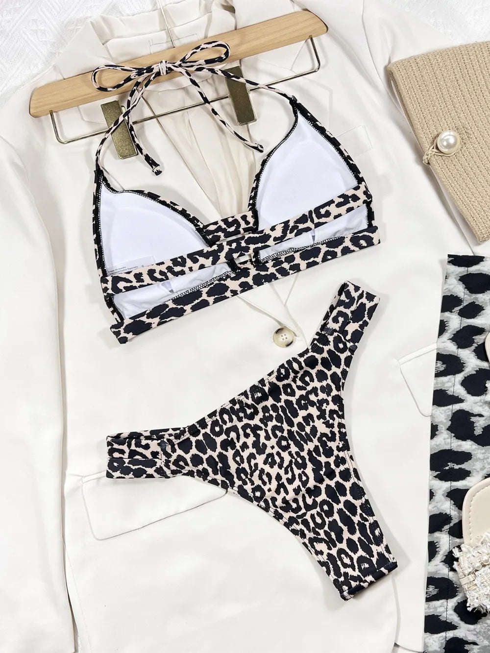 The striking leopard pattern swimsuit pairs with a sleek V‑neck halter top and backless detail, creating a silhouette that’s both fierce and flattering.