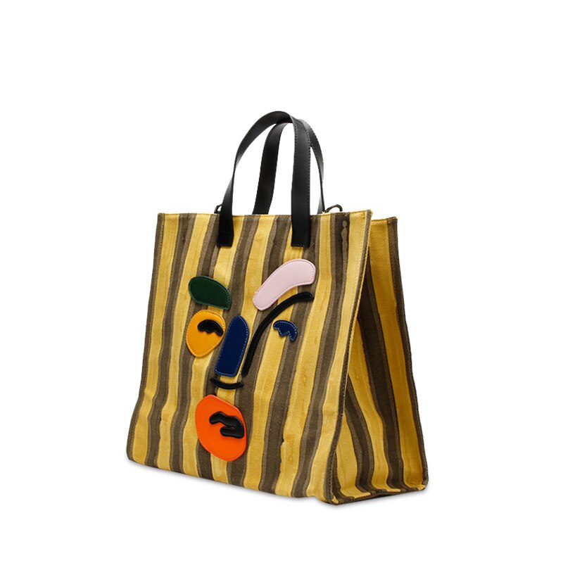 Large yellow striped canvas tote with polyester cotton lining. Modern faceless print, reinforced handles, perfect for beach days and everyday errands.