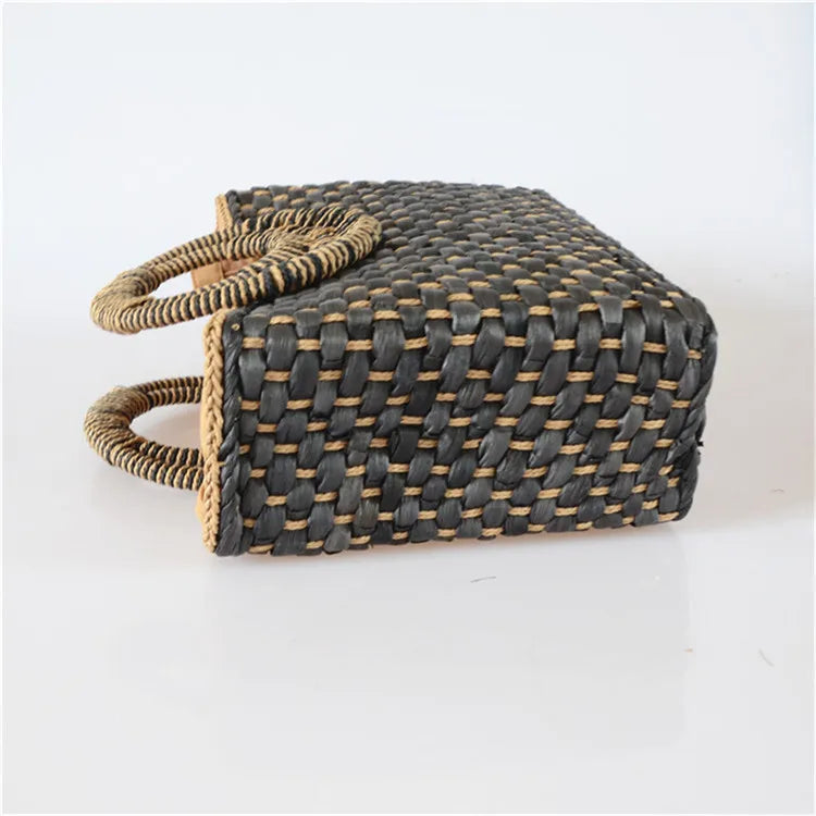 Woven handbag with black and beige pattern on a white background