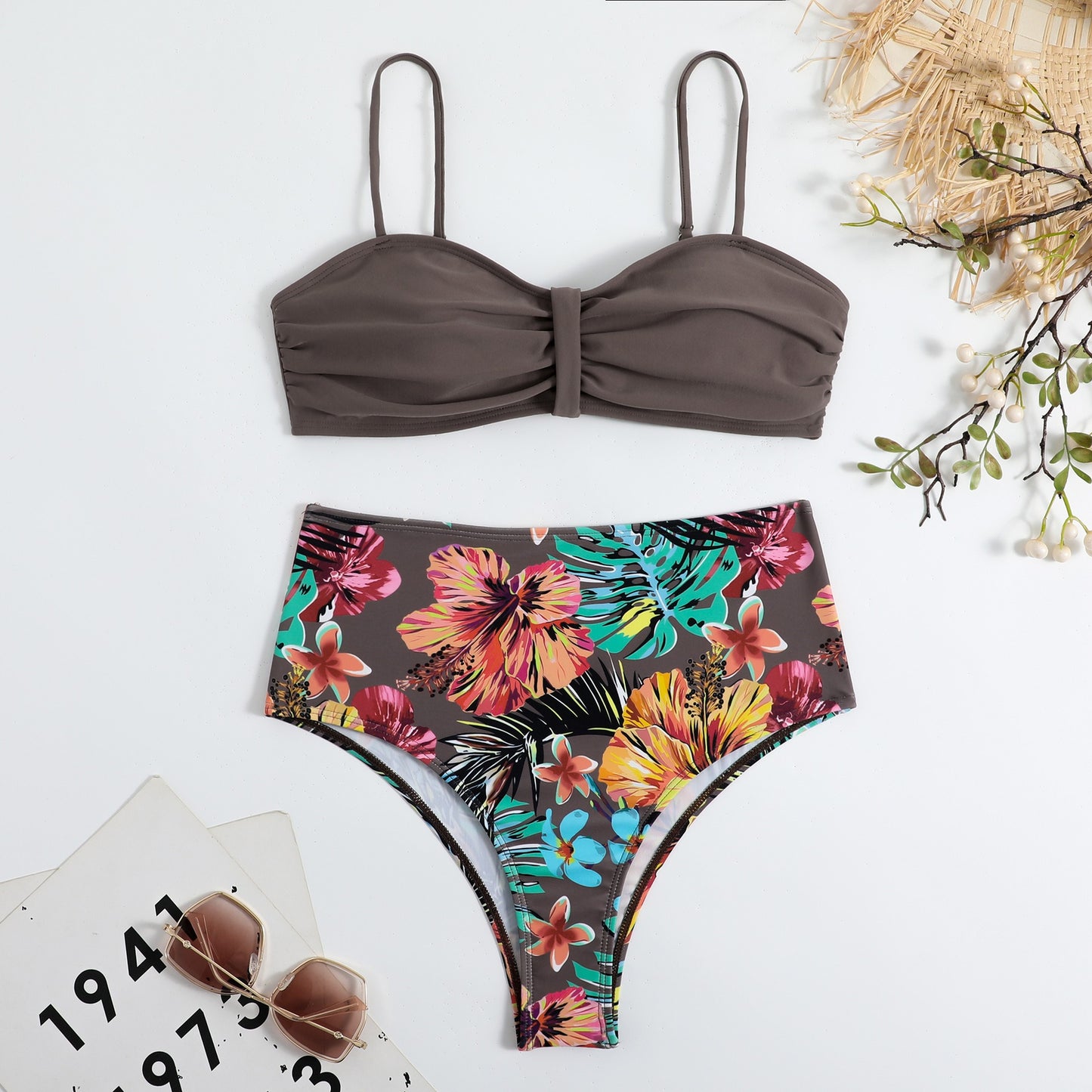 This two‑piece high‑waist bikini features a fragmented floral pattern blending bright color with a flattering, modern silhouette. 