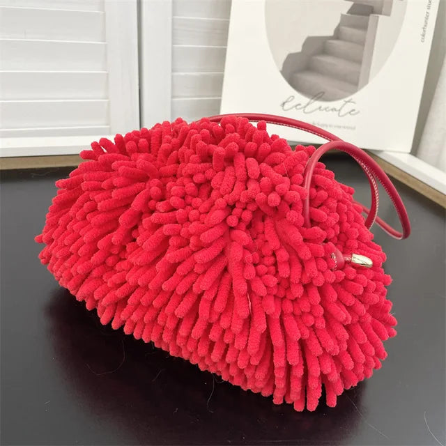 Person holding a red textured handbag against a white wall sold at PeachyBeanz.