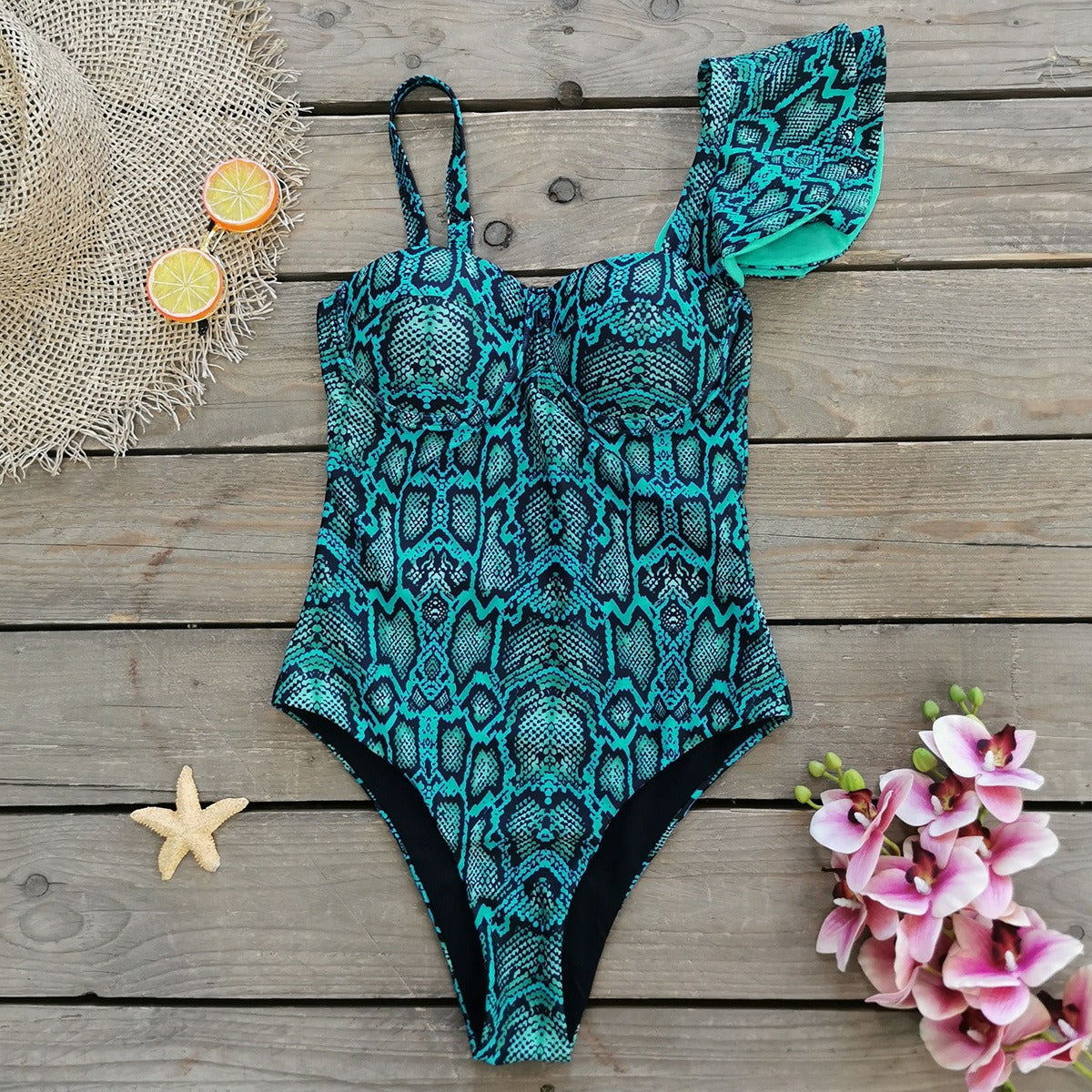 Teal and black patterned swimsuit on a wooden surface