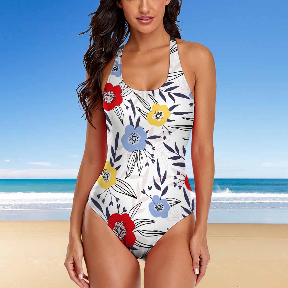 Woman wearing a floral swimsuit against a beachy background sold at PeachyBeanz. 