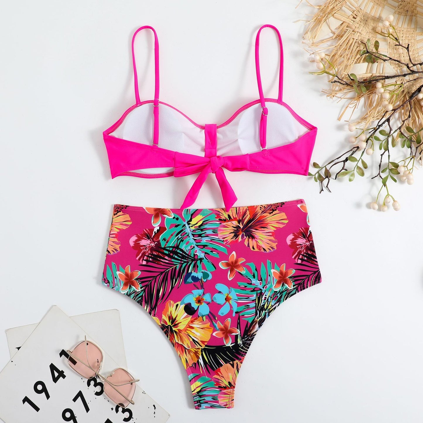 This two‑piece high‑waist bikini features a fragmented floral pattern blending bright color with a flattering, modern silhouette. 