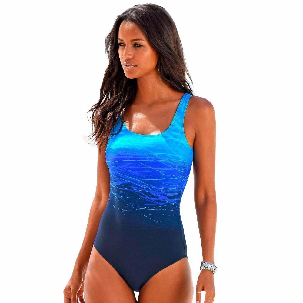 Woman wearing a blue swimsuit with a plain white background