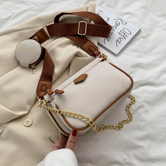 White handbag with a gold chain strap in an indoor setting sold at PeachyBeanz.