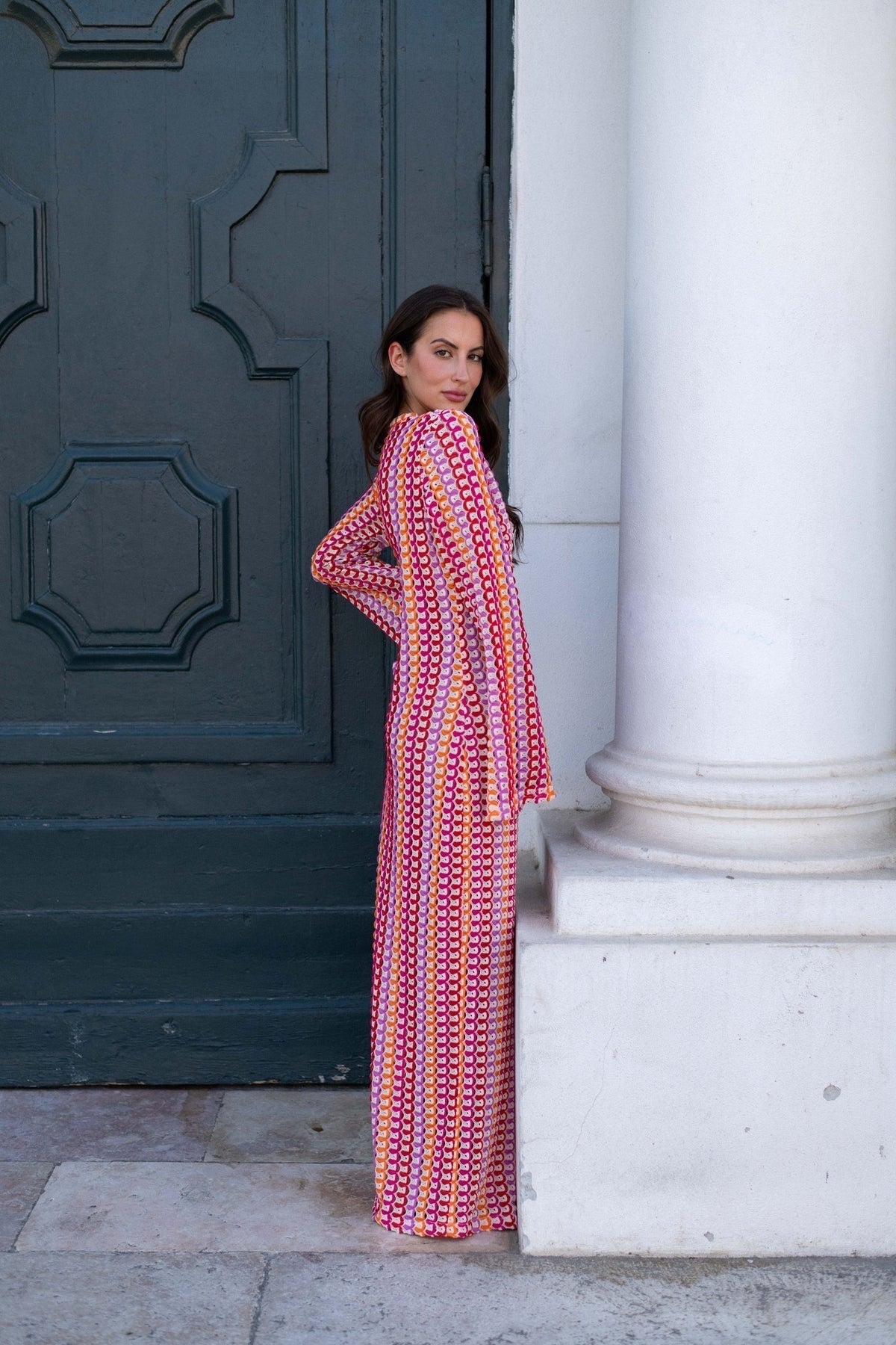Person standing in a colorful swimsuit cover-up dress with a patterned design