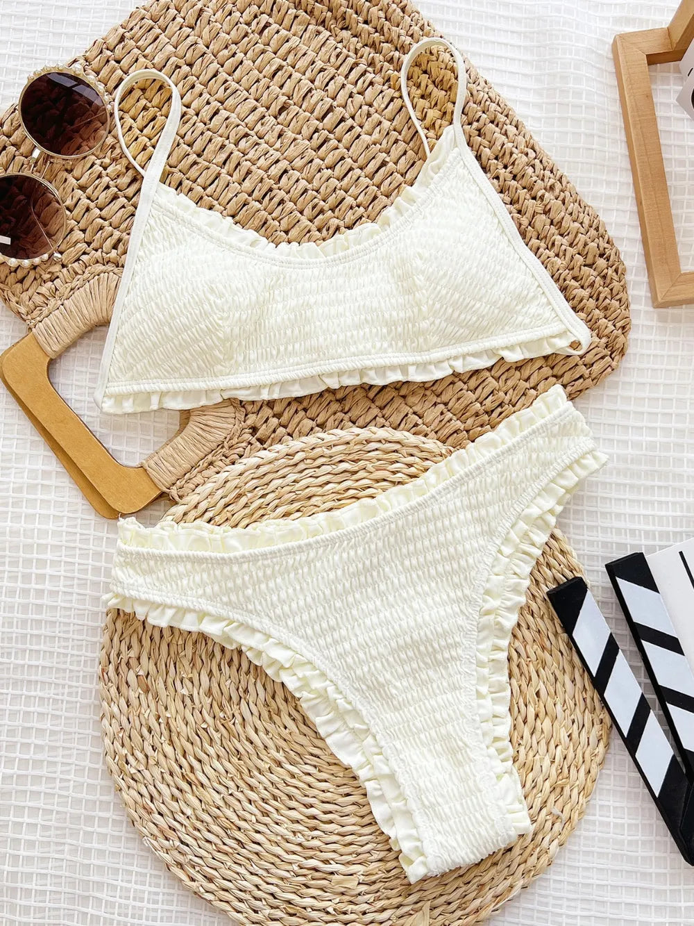 White scrunchy-patterned bikini with matching top and bottom, featuring spaghetti straps.