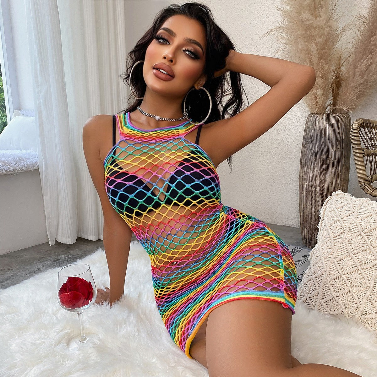 Vibrant fishnet coverup featuring multicolor yarns, geometric cutout panels, and a cropped, boxy silhouette that layers over swimwear.