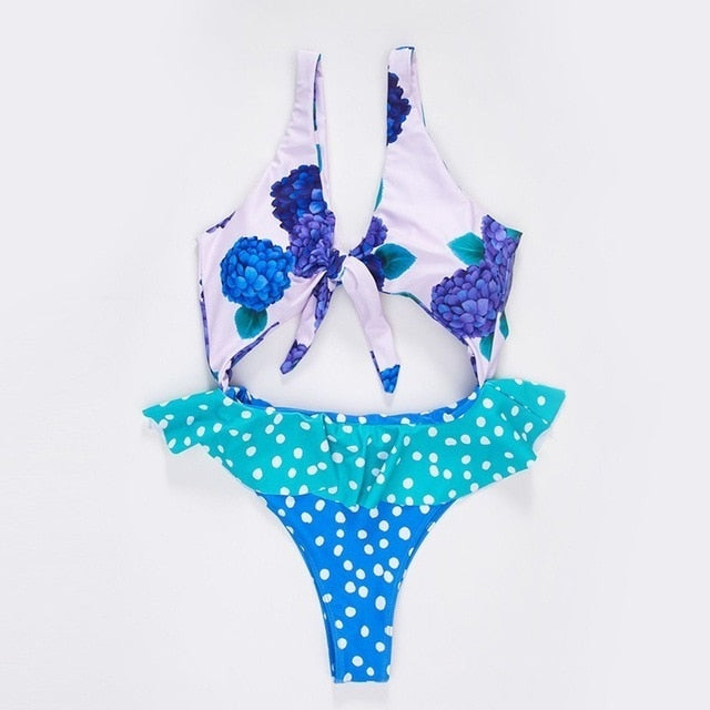 Women’s one‑piece swimsuit featuring a blue floral print and sleeveless design.