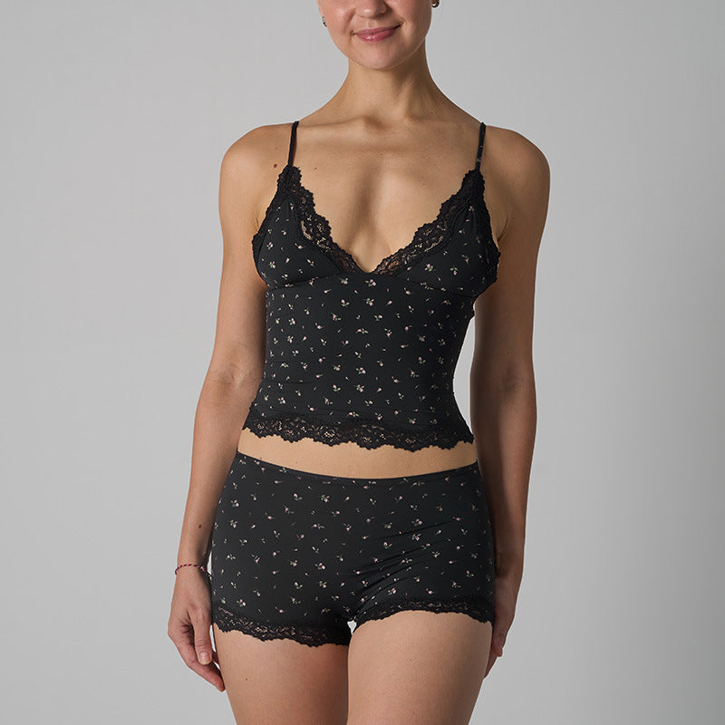 Black lace lingerie set worn by a model on a gray background