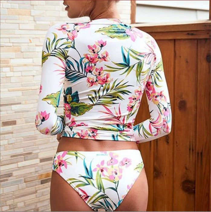 Person wearing a colorful floral long-sleeve top and shorts.