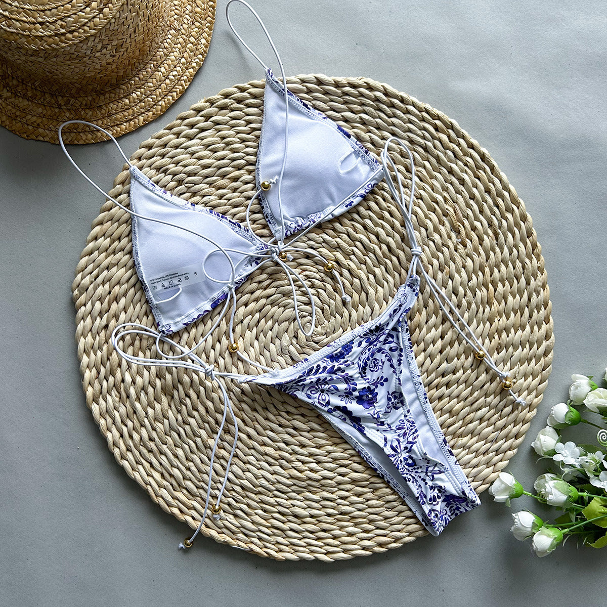 Purple printed two‑piece bikini with adjustable tie‑up straps and triangle‑style bottoms displayed on a plain background.
