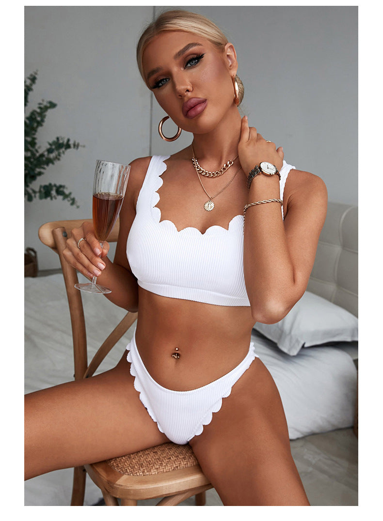Woman in a white bikini holding a glass of champagne in a casual setting sold at PeachyBeanz.