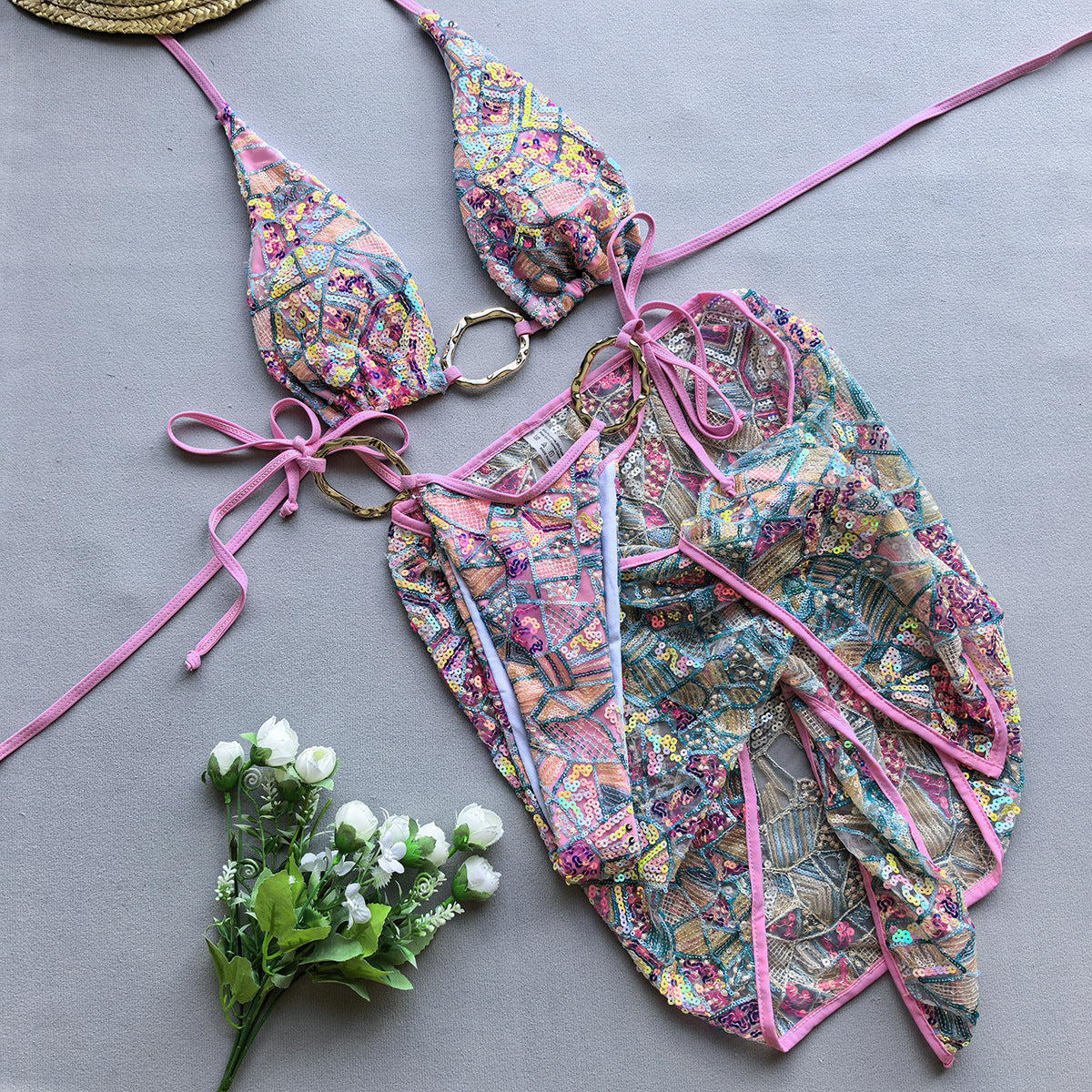 Pink three‑piece women’s bikini set with spaghetti‑strap top, matching bottoms, and cover-up, displayed on a plain background.