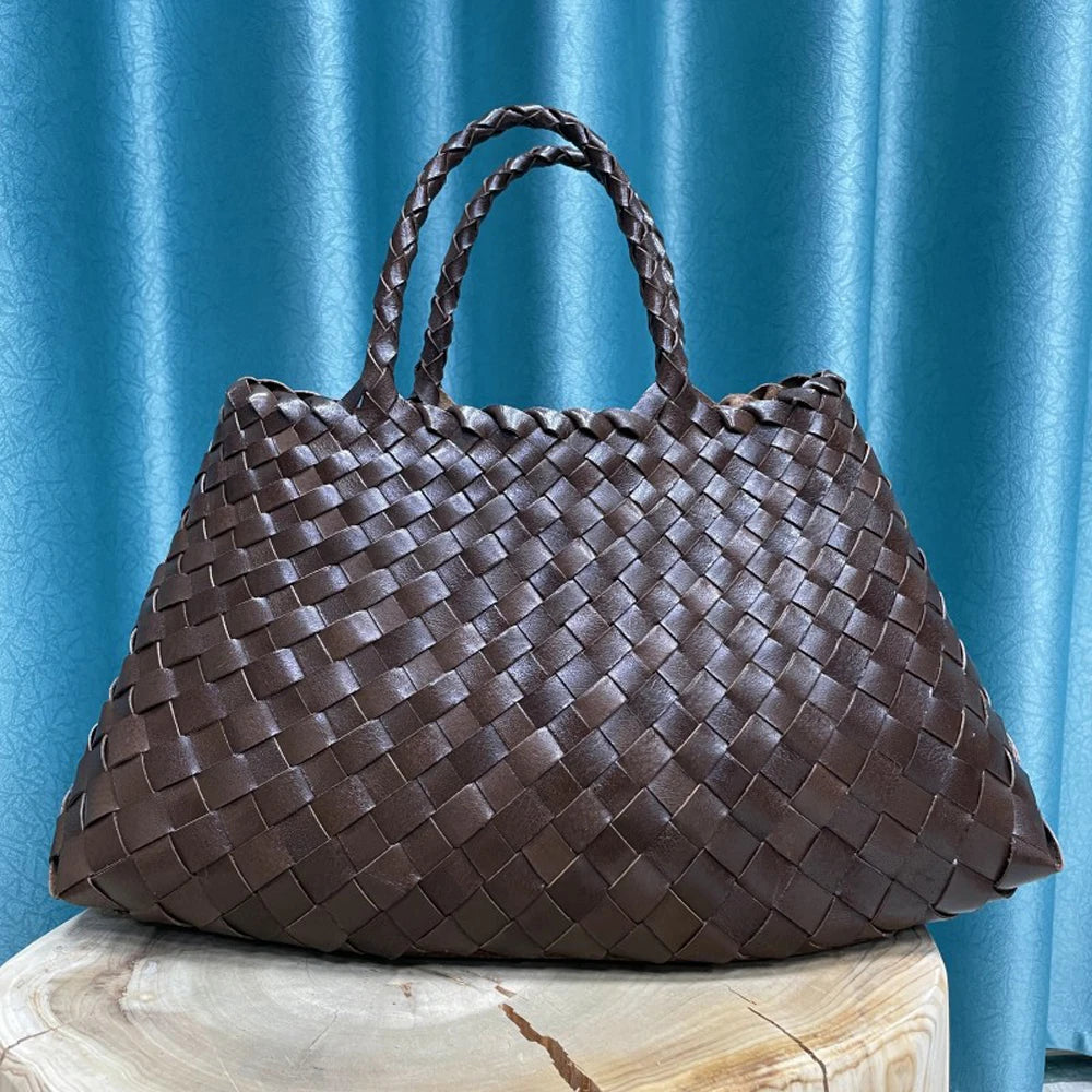 Black woven handbag on against a plain background