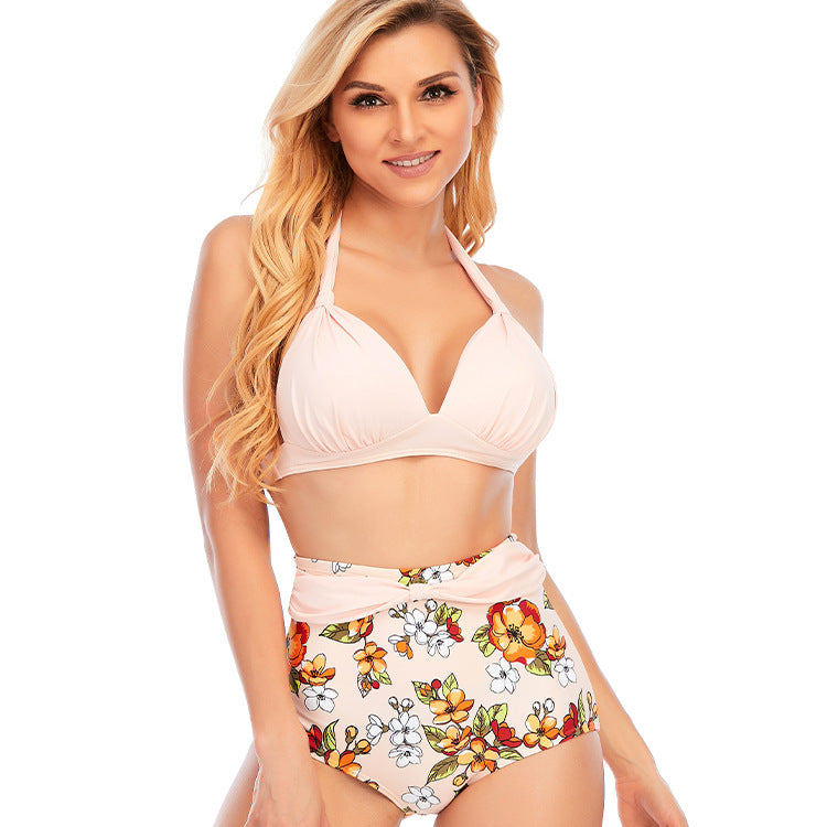 Woman wearing a white halter bikini top and high‑waisted matching floral bottoms.