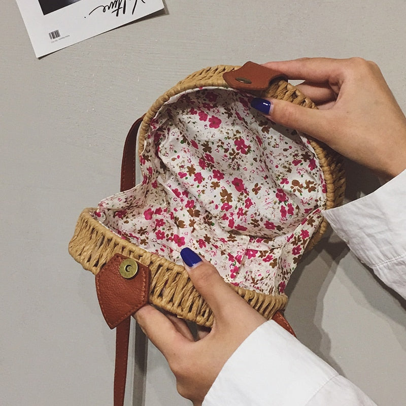 Woven handbag with leather straps on a white background