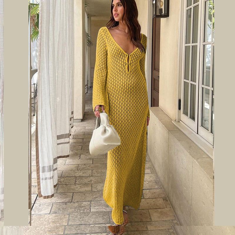 Woman in a yellow textured dress standing in front of a building entrance.
