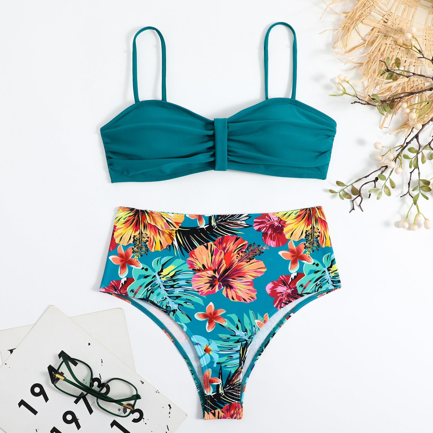 This two‑piece high‑waist bikini features a fragmented floral pattern blending bright color with a flattering, modern silhouette. 