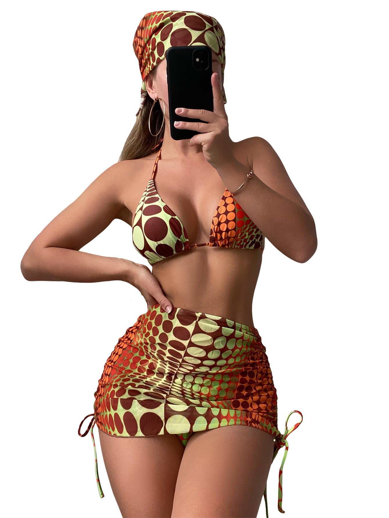Woman taking a mirror selfie wearing a colorful patterned bikini and headscarf on a white background