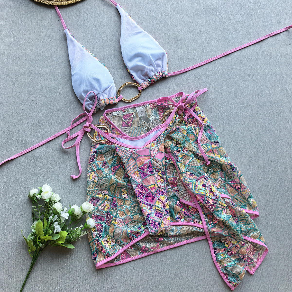 Pink three‑piece women’s bikini set with spaghetti‑strap top, matching bottoms, and cover-up, displayed on a plain background.