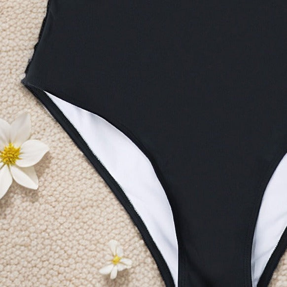 Off‑the‑shoulder one‑piece swimsuit with ruched bodice and short sleeves.