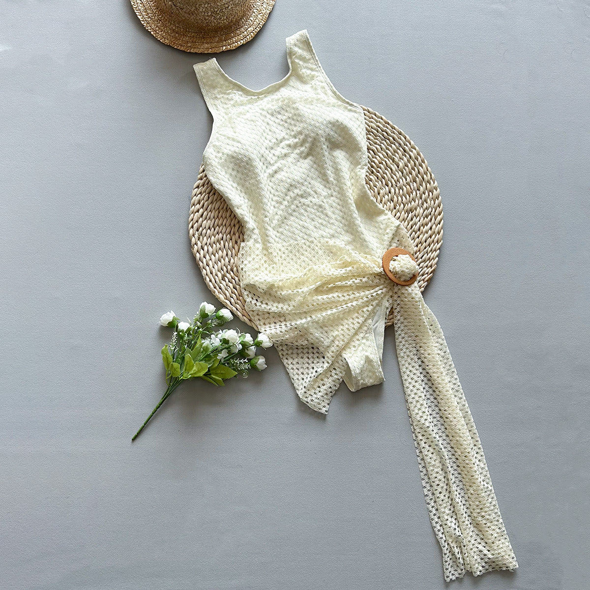 White woven swimsuit and sarong against a grey setting sold at PeachyBeanz.