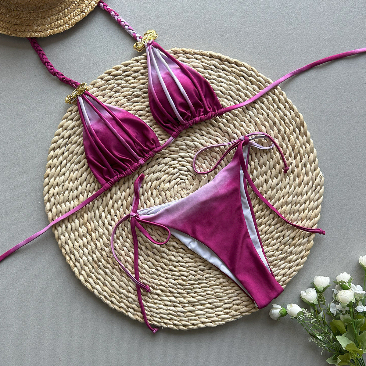 Pink bikini set with gold accents on a white background