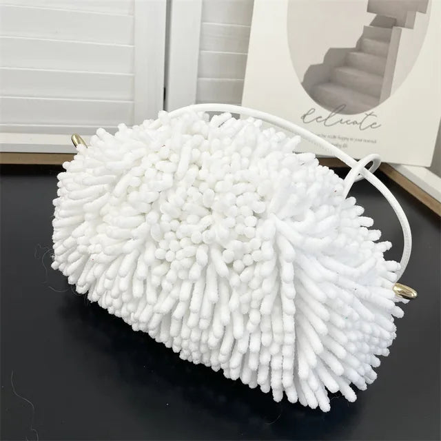 Person holding a white textured handbag against a white wall sold at PeachyBeanz.