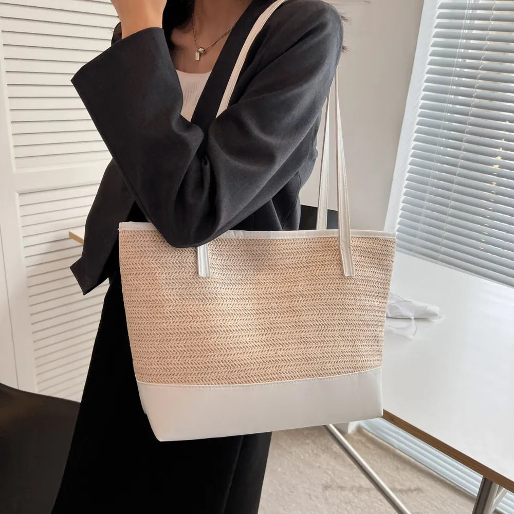 Large white straw bag laying down on white cloth.