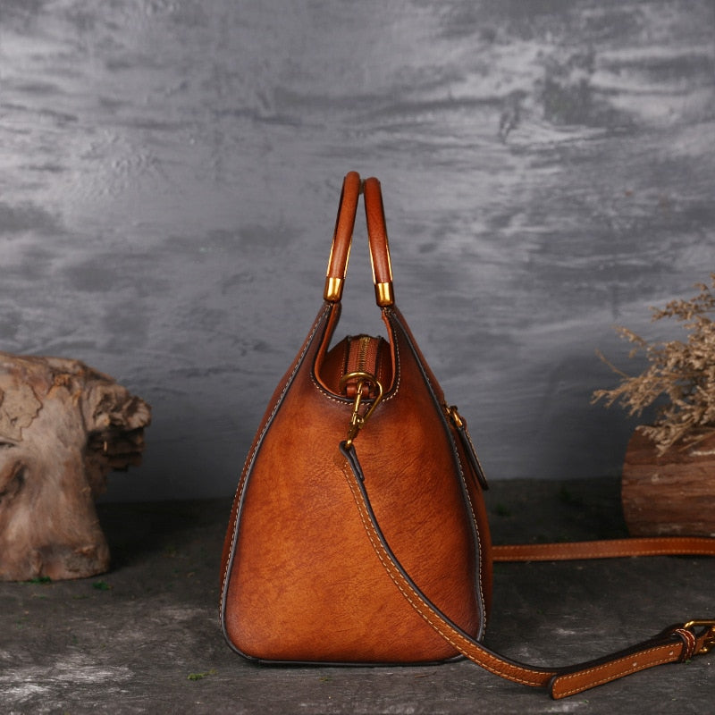 Tan genuine cow leather handbag with polished hardware.
