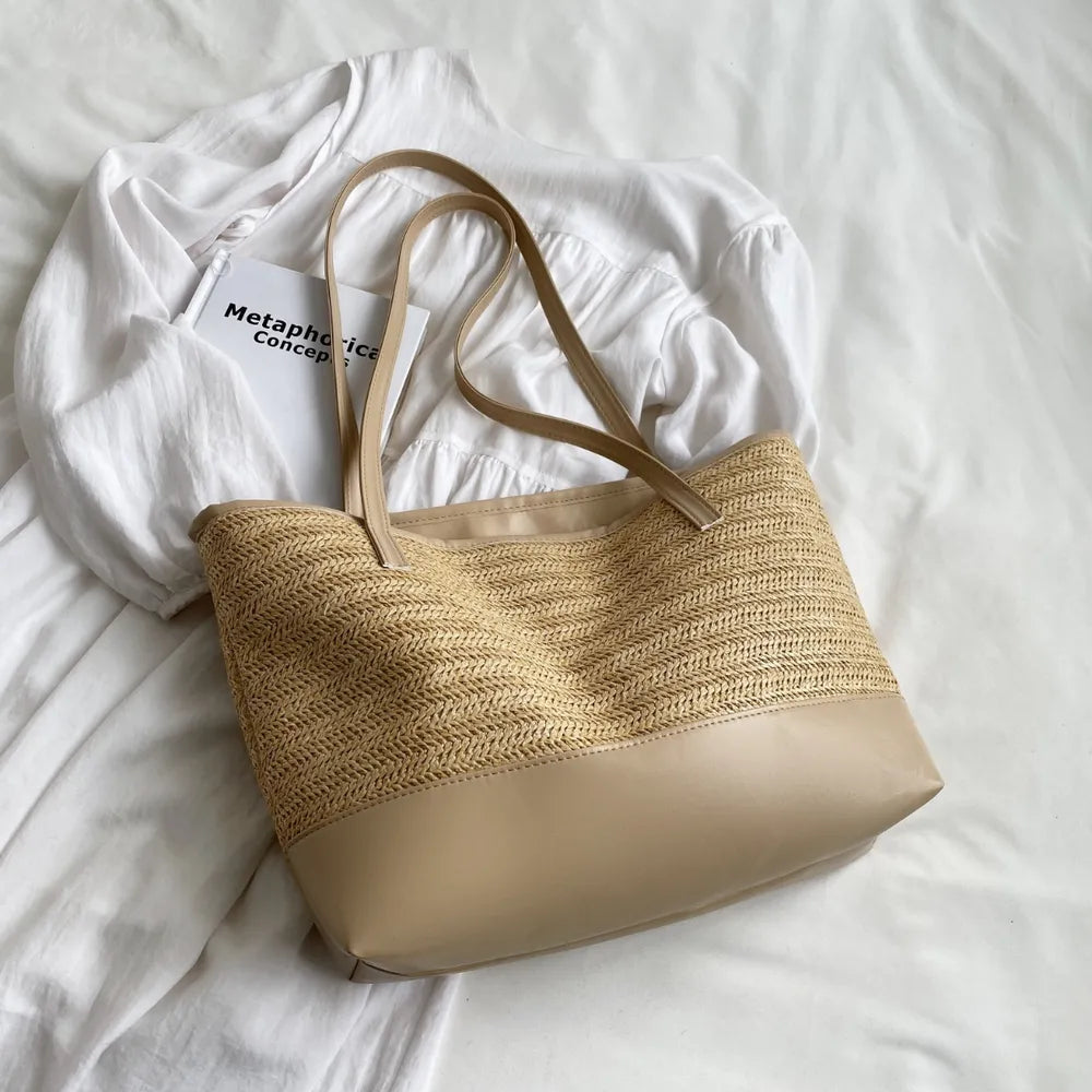 Large beige straw bag laying down on white cloth.