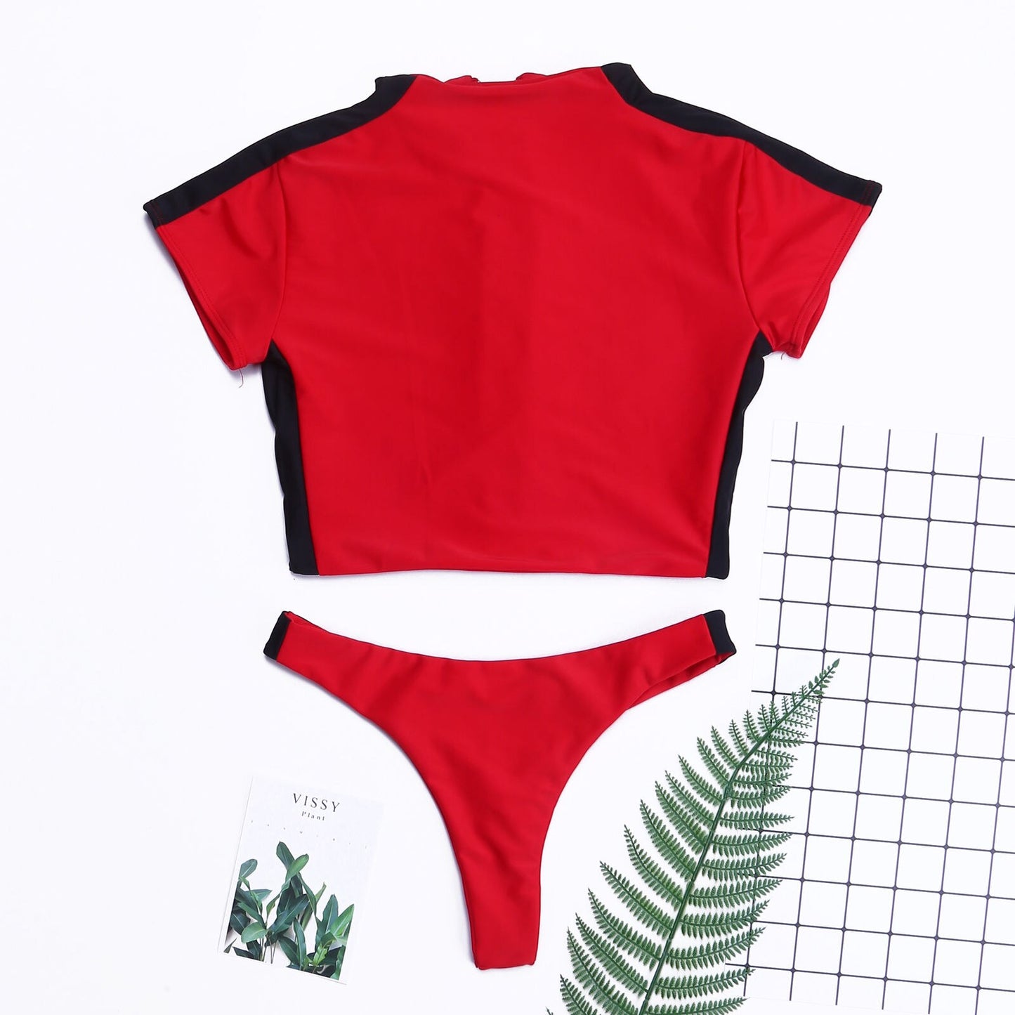 Women’s short‑sleeve two‑piece swimsuit with a front zip‑up top and matching bikini bottoms, shown in a solid color on a plain background.