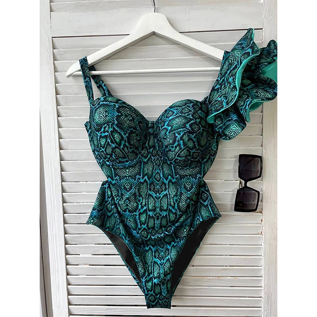 Teal and black patterned swimsuit on a wooden surface