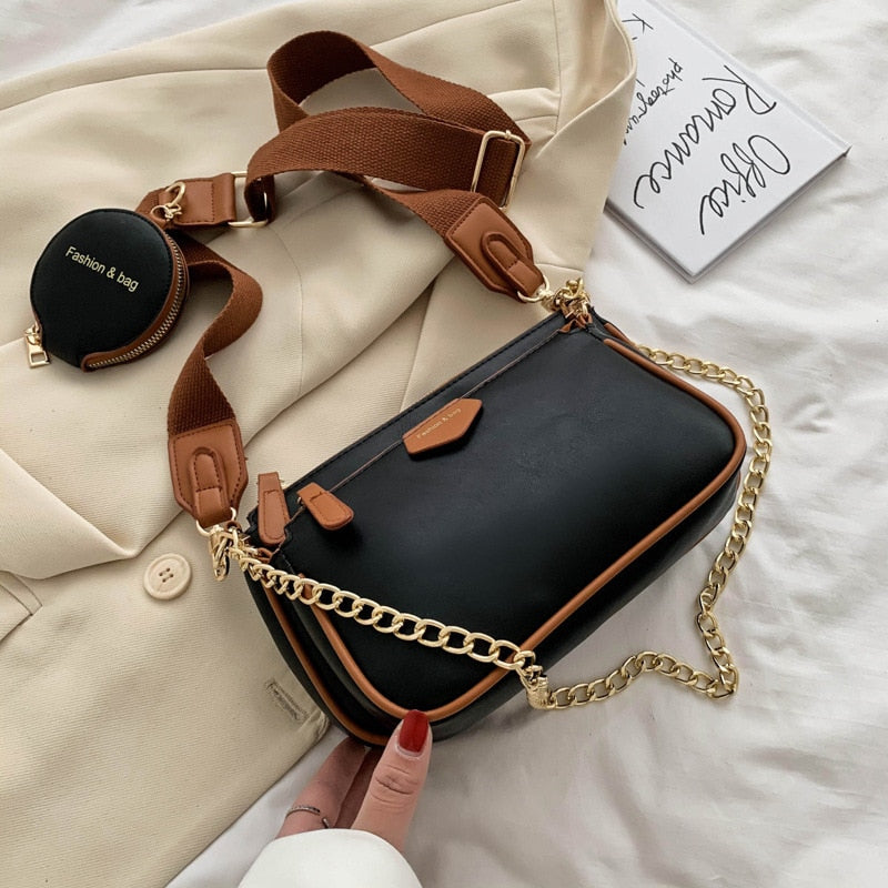 Black handbag with a gold chain strap in an indoor setting sold at PeachyBeanz.