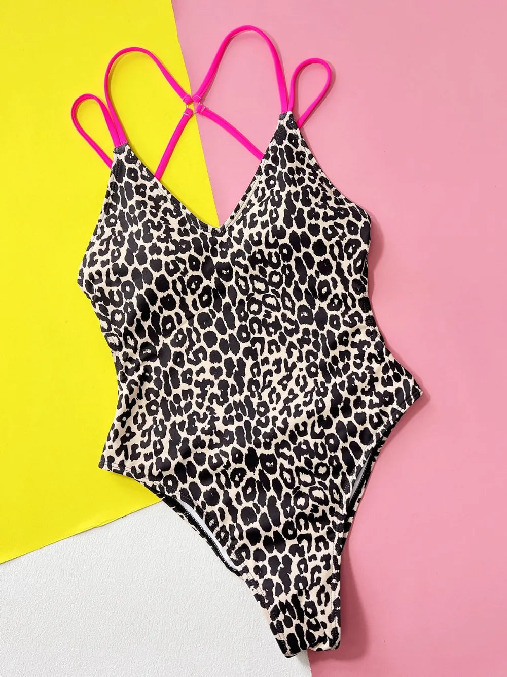 Leopard print one-piece swimsuit against a colorful background