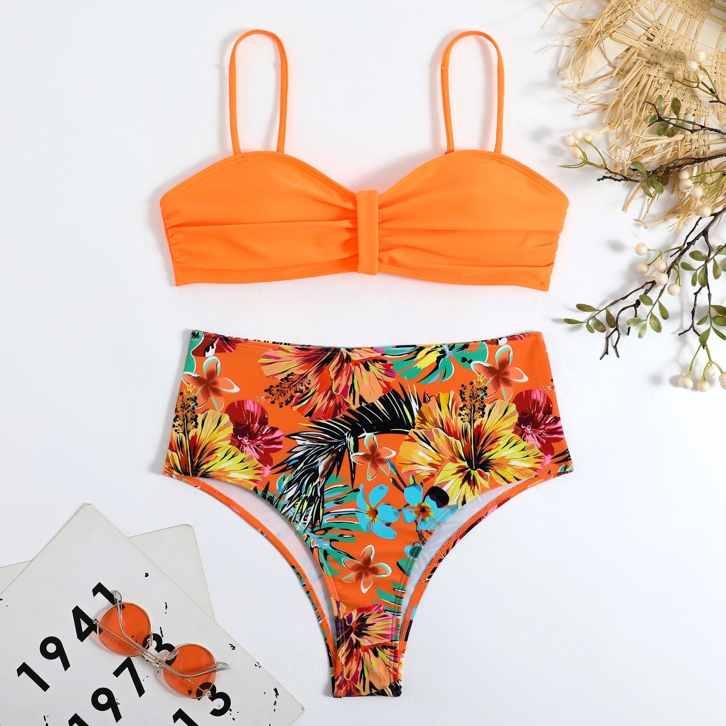 This two‑piece high‑waist bikini features a fragmented floral pattern blending bright color with a flattering, modern silhouette. 