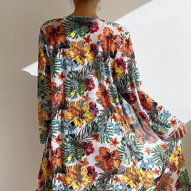 Long sleeve flared cover up with split hem, paired with coordinating bikini and skirt; lightweight printed fabric and relaxed fit.